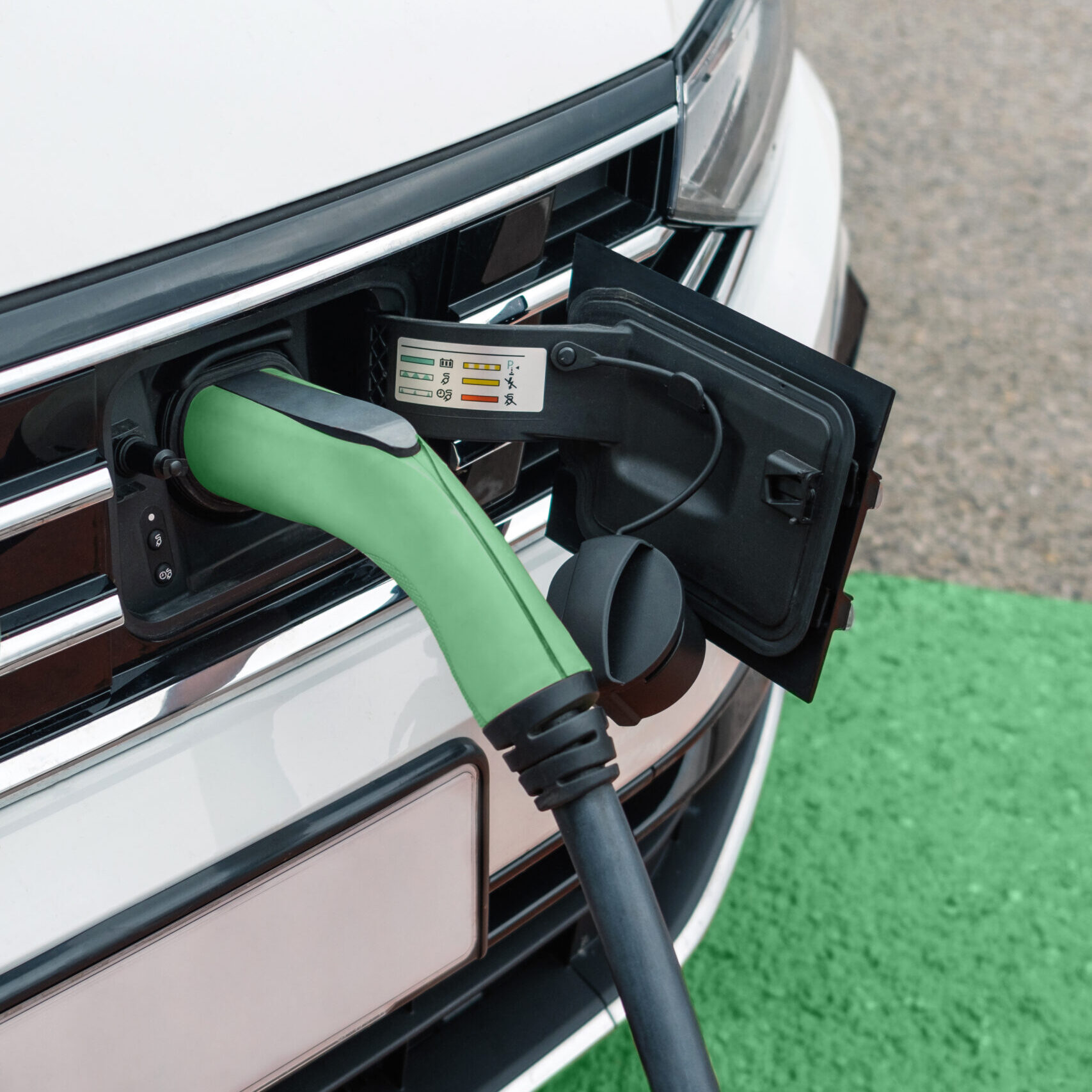 Detail of socket plugged into electric car outdoors
